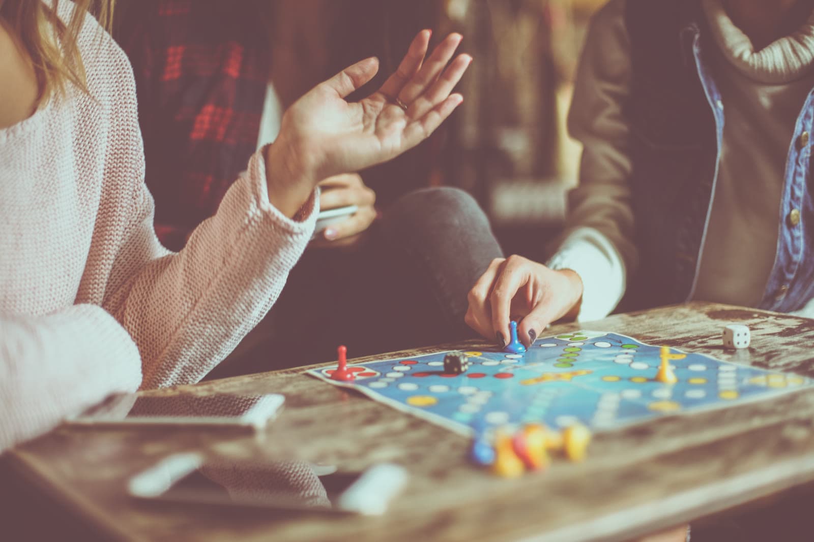 Hands mid-move over a board game at a kitchen table